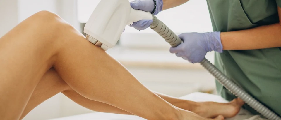 Laser hair removal on the lower leg: a cooled handpiece held against the skin.